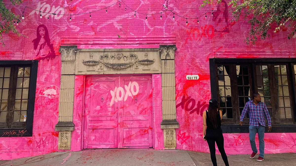 XOXO Social Club exterior mural by not.travis in Dallas, extending across the building and pavement